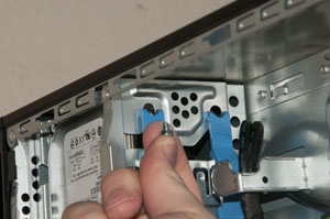 Tightening second screw to secure hard drive